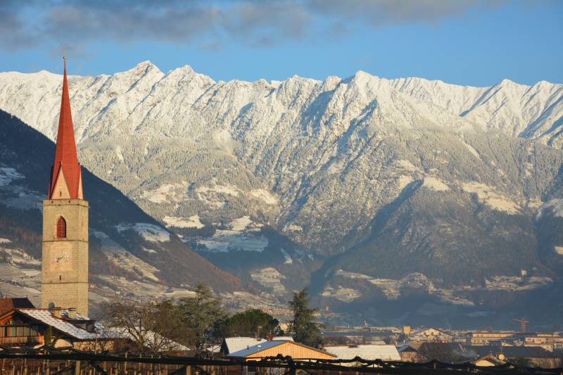 Kirchturm mit Berge im Hintergrund